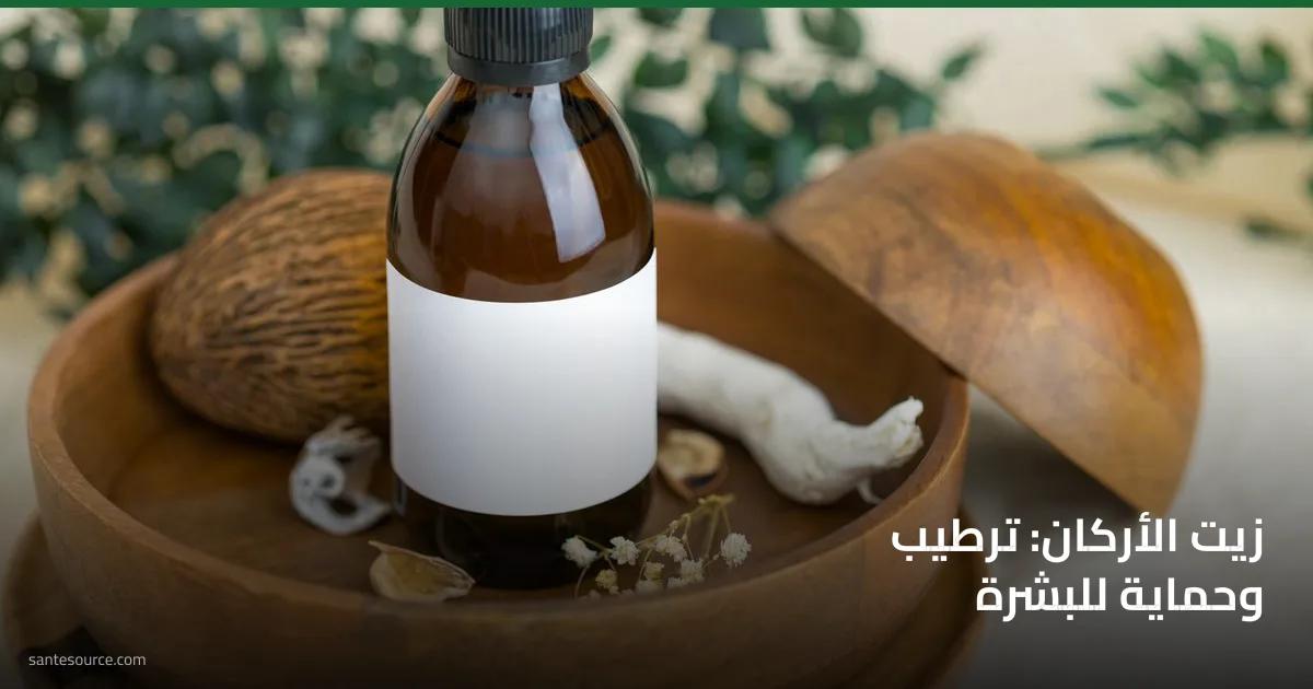 زجاجة زيت الأركان الداكنة على طبق خشبي مع مكوّنات طبيعية، ترطيب وحماية للبشرة