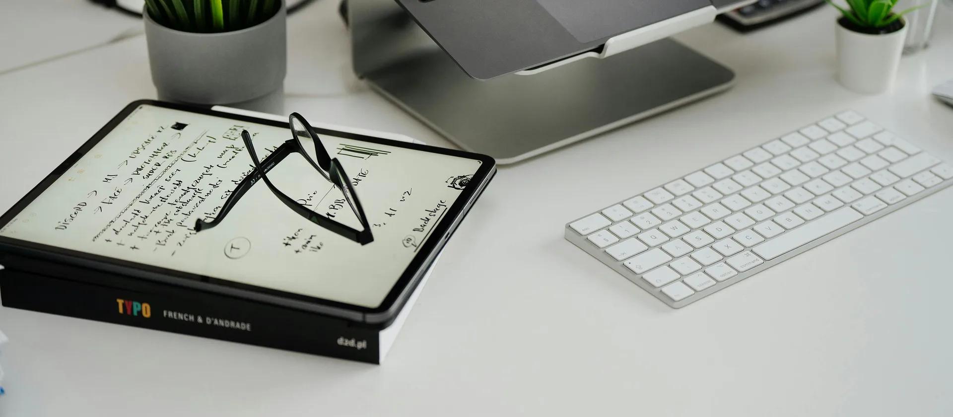 Bureau de recherche moderne avec carnet, ordinateur et plantes, ambiance scientifique sobre.